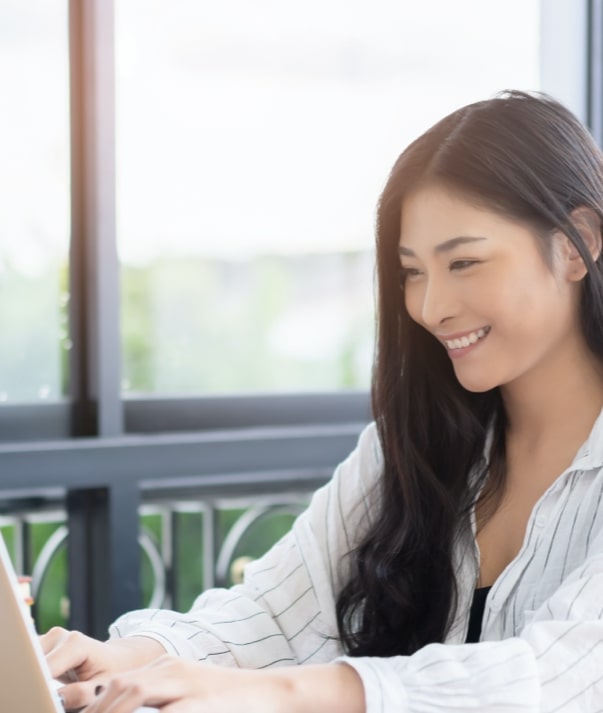 Smiling female Invesco employee working on a laptop computer